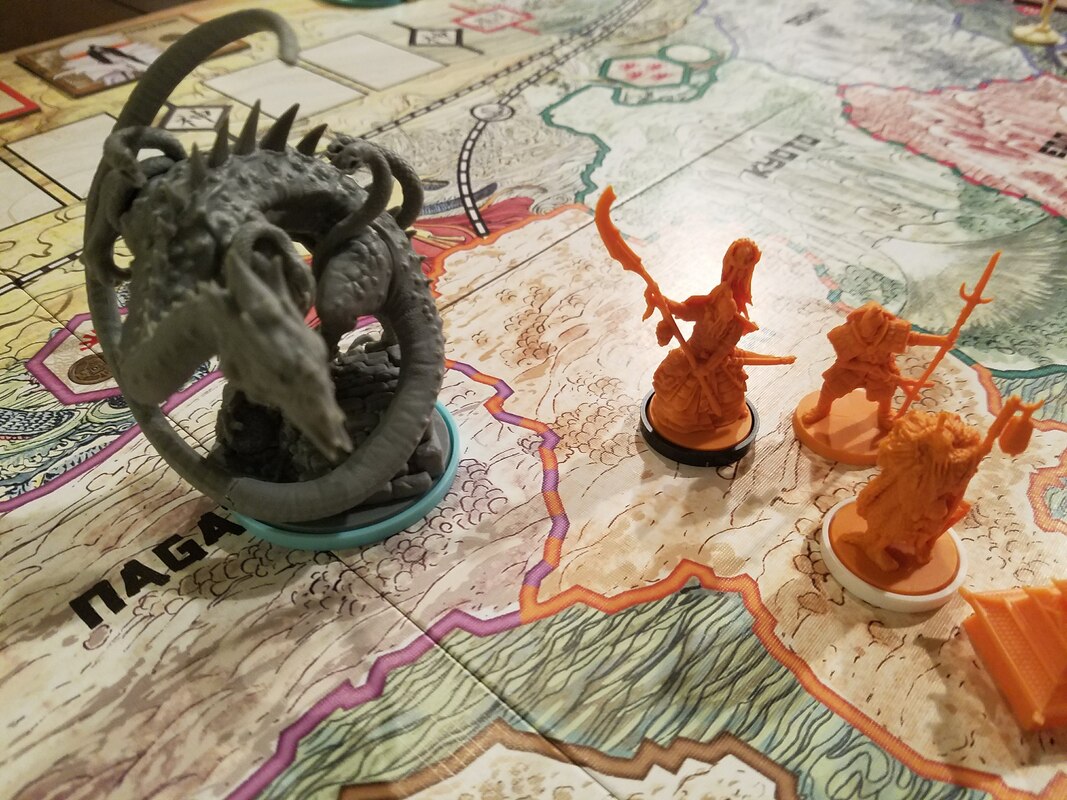 Figures fight monster on gaming map