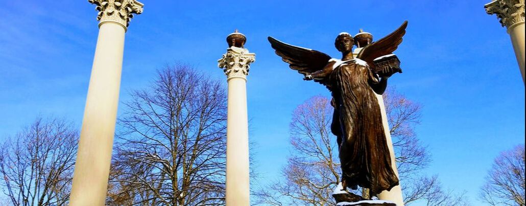 Ball State Beneficence statue in snow with blue sky