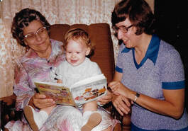 Grandmother and mother read to baby 
